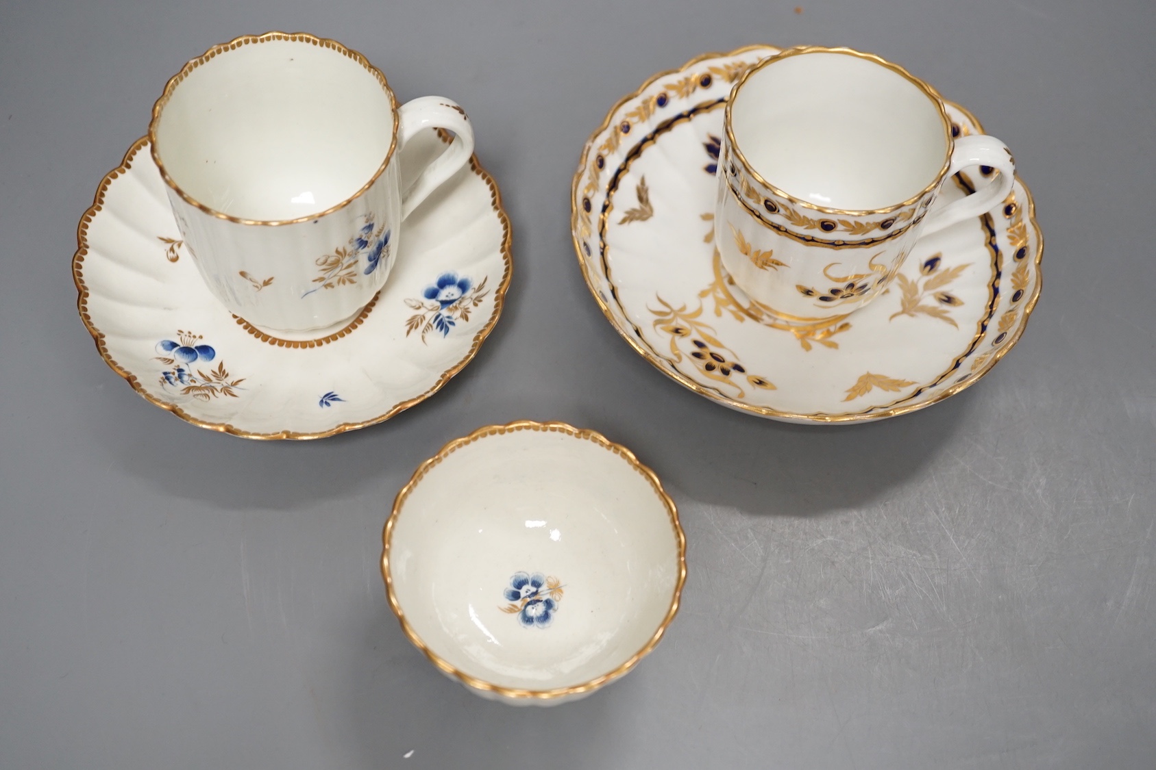 A Worcester fluted coffee cup, teacup and saucer painted with dry blue flowers and gilt foliage and a fluted coffee cup and saucer with blue and gilt decoration c.1775 and later